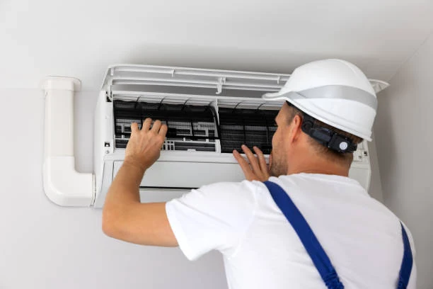 Technician fitting filters in a wall-mounted air conditioning unit