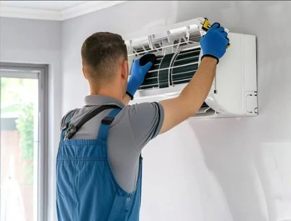 Technician inspecting the filters and coils of an indoor air conditioning unit